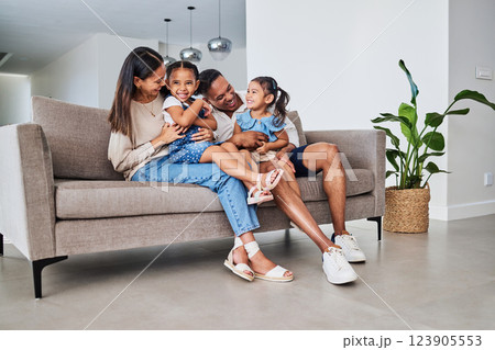 Family, children and laugh with a girl, sister and parents sitting on a sofa in the home living room together. Kids, laugh and humor with a mother, father and daughter siblings bonding in a house 123905553