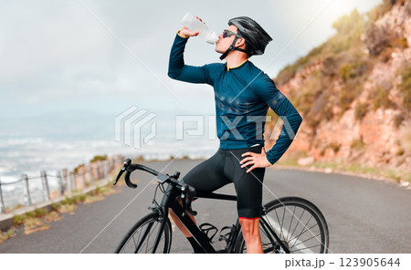 Cyclist, drinking water or fitness break on road in workout, training or exercise in competition race, health wellness. Sports man, bike athlete or thirsty cycling person on France countryside street Cyclist, drinking water or fitness break on road in workout, training or exercise in competition race, health wellness. Sports man, bike athlete or thirsty cycling person on France countryside street 123905644