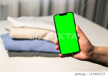 Copy space smartphone donation of clothes. Renewable concept. Selling online old used clothes. Zero waste, resell. 123905717