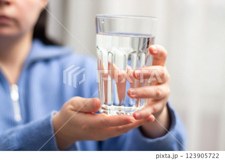 Close up image of woman holding glass of water. Concept of water balance. Long living. Healthy wellbeing. Close up image of woman holding glass of water. Concept of water balance. Long living. Healthy wellbeing. 123905722