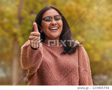 Thumbs up, support and woman with smile in a park for peace, relax and happiness. Portrait of a happy, young and winning girl with hand sign for thank you, motivation and agreement in nature 123905748