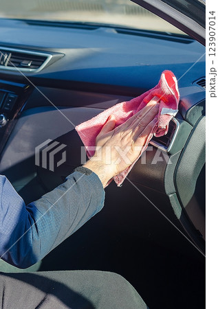 Hand wiping car dashboard with a microfibre cloth. High quality photo Hand wiping car dashboard with a microfibre cloth. High quality photo 123907014