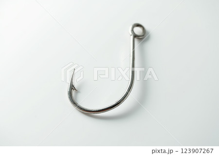 Metal fishing hook resting on a white background showcasing its sharp curve and sturdy design 123907267