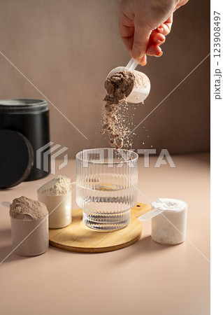 Chocolate protein powder pouring in a glass. Food supplement, fitness sport, health and nutrition. 123908497