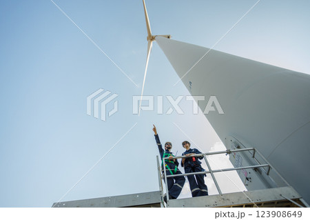 Team engineer wind turbine worker safety uniform survey discuss operational planning windmill field clean energy. Alternative technology protect environment reduce global warming problems. 123908649