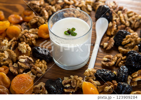 natural yogurt with nuts, dried apricots and prunes on a wooden table 123909284