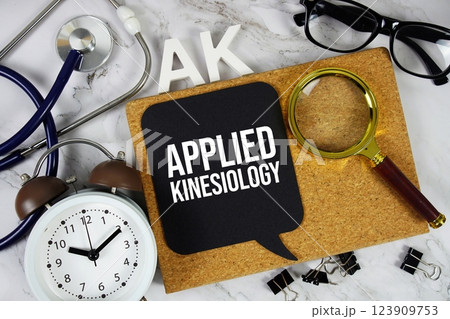AK Applied Kinesiology acronym with alarm clock and magnifying glass, medical and healthcare concept background 123909753