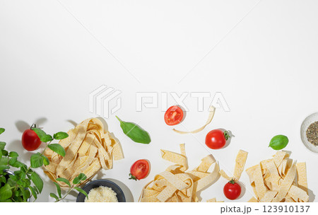 Flat-lay of fresh pasta with tomatoes and basil on white background. Flat-lay of fresh pasta with tomatoes and basil on white background. 123910137