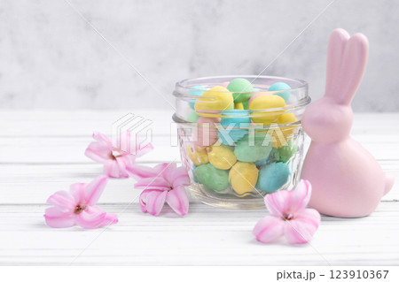 Easter bunny, jar with sweet eggs and hyacinth flowers. 123910367