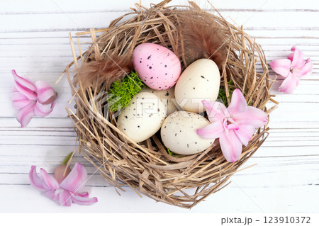 Easter nest with speckled eggs, moss and pink flowers. Easter nest with speckled eggs, moss and pink flowers. 123910372
