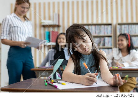 School children education in classroom. kid schoolgirl happy learning. Writing as instructed by teacher. concept of back to school. 123910423