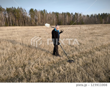 man with a metal detector. Man with electronic metal detector device in his hand. 123911008
