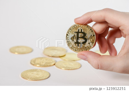 shiny bitcoin coin with multiple golden bitcoins on white background, concept of cryptocurrency investment and digital finance 123912251