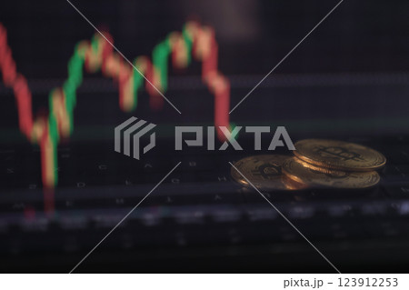 bitcoins on laptop keyboard with blurred cryptocurrency trading chart in background, digital currency and financial market concept bitcoins on laptop keyboard with blurred cryptocurrency trading chart in background, digital currency and financial market concept 123912253