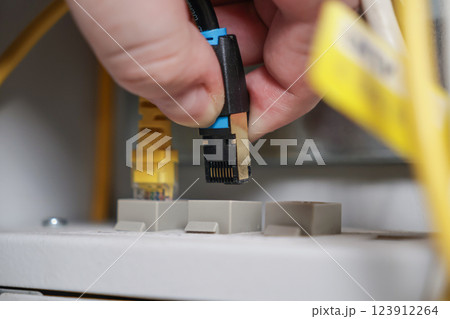 technician connecting ethernet cable to network port, close-up of internet setup process, IT infrastructure and technology concept 123912264