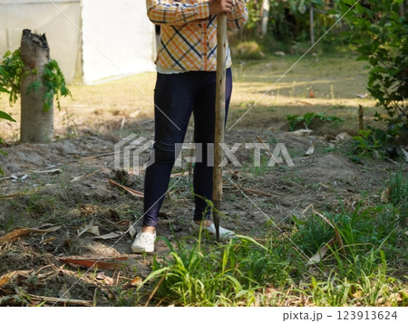 Asian adult woman working outdoors in summer garden. 123913624