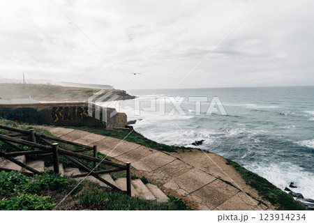 Dramatic cliffs of Cape Roca, Portugal, meet the powerful Atlantic Ocean under a cloudy sky. 123914234