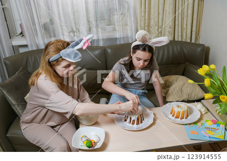 Mother and daughter decorating Easter cakes together. 123914555