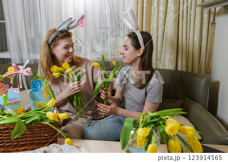 Mother and daughter celebrating Easter with yellow tulips. Mother and daughter celebrating Easter with yellow tulips. 123914565