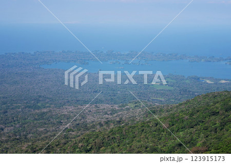 Scenic view of lush mountains overlooking serene blue lake at midday 123915173