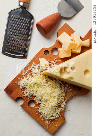 Grated cheese, Maasdam, on a cutting board, grater and cheese knife, close-up, no people, 123915258