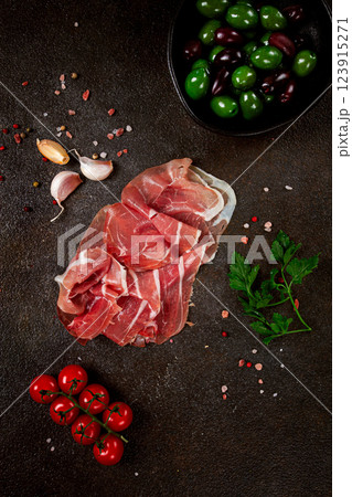 Sliced ham, on a dark background, with cherry tomatoes, and green giant olives, top view, no people, Sliced ham, on a dark background, with cherry tomatoes, and green giant olives, top view, no people, 123915271