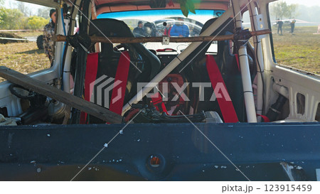 Rear view of the interior of the SUV with racing seats and safety equipment. The vehicle is being prepared for a race. Red racing seats, seat belts, safety cage 123915459