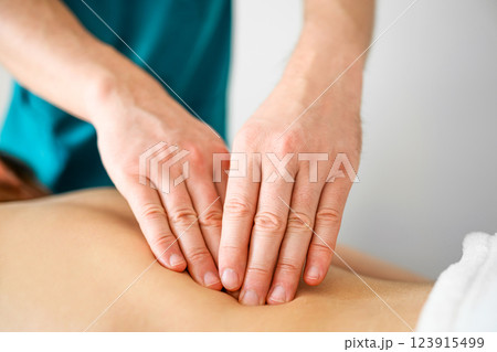 Professional masseur therapist doing massage of trigger points on a back 123915499