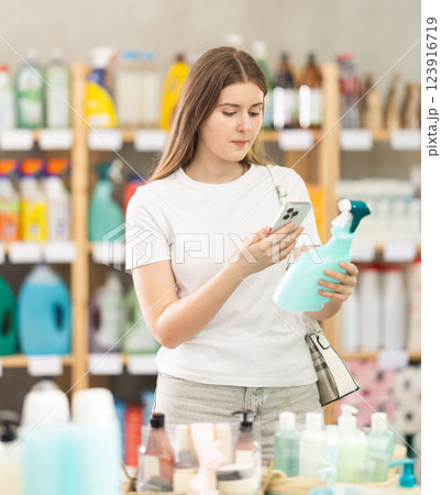 Girl buyer scans qr code on tile cleaner spray label Girl buyer scans qr code on tile cleaner spray label 123916719