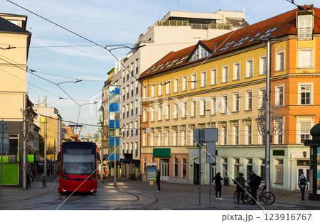 Modern tram travels along a quiet Hurbanovo street in Bratislava during day with historical architecture in view 123916767