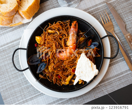 Spanish seafood fideua, noodle paella with aioli 123916791