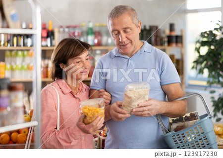 Couple elderly man and woman choosing flakes in grocery store 123917230