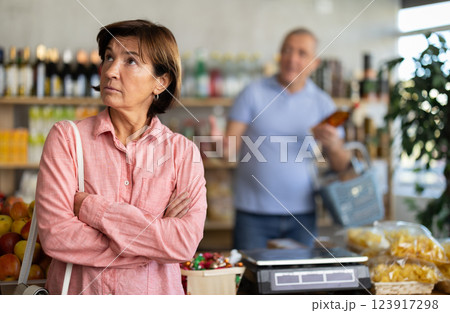 Senior husband stands behind pensioner wife and yells at companion 123917298