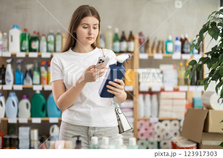 Checking expiration date of spray glass cleaner for windows - female shopper scans QR code on label of spray glass cleaner for windows using smartphone Checking expiration date of spray glass cleaner for windows - female shopper scans QR code on label of spray glass cleaner for windows using smartphone 123917303