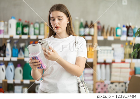 Female shopper scans QR code on label of razor for windows using smartphone 123917484