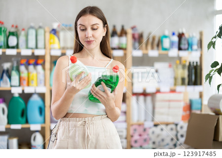 European woman chooses dishwashing detergent from different manufacturers 123917485