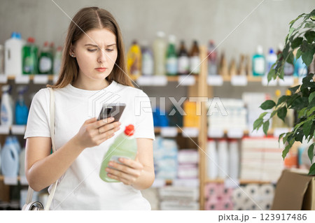Girl buyer scans qr code on dishwashing soap label 123917486