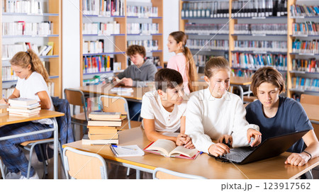 Group of girls and boys preparing for exams in library 123917562