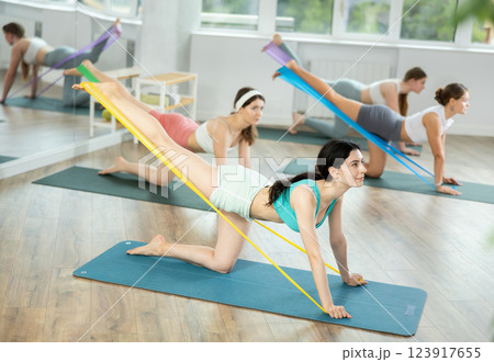 Group of young women doing pilates with band 123917655