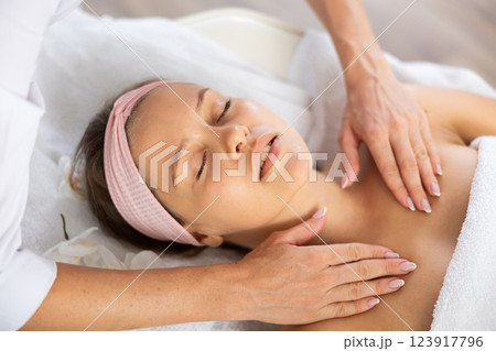Young woman gets massage of her collarbones and neck Young woman gets massage of her collarbones and neck 123917796