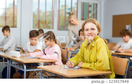 Young girl studying in school with classmates Young girl studying in school with classmates 123917849