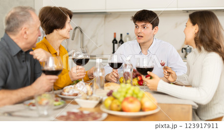 Happy family having dinner together at festive table at home Happy family having dinner together at festive table at home 123917911