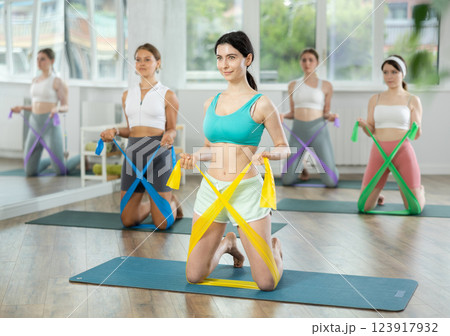 Group of young women doing pilates with band 123917932