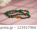 Malachite necklace photographed on a pink background 123917966