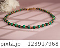 Malachite necklace photographed on a pink background 123917968