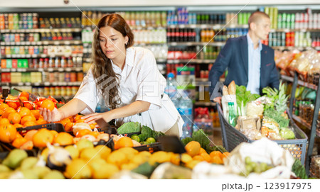 Female shopper picks ripe oranges on grocery store Female shopper picks ripe oranges on grocery store 123917975