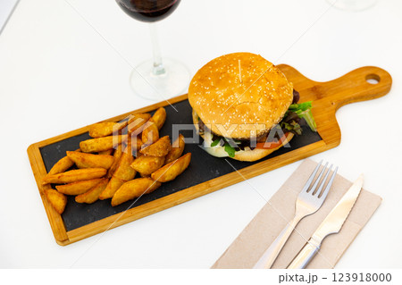 Delicious cheeseburger with beef patty and cheese on plate, with french fries Delicious cheeseburger with beef patty and cheese on plate, with french fries 123918000