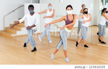 People in protective masks learning swing steps at dance class People in protective masks learning swing steps at dance class 123918105