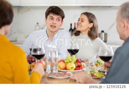Cheerful young couple having dinner with elderly parents Cheerful young couple having dinner with elderly parents 123918126