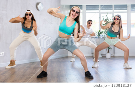 Teenage girl practicing hip-hop movements during group dance class Teenage girl practicing hip-hop movements during group dance class 123918127